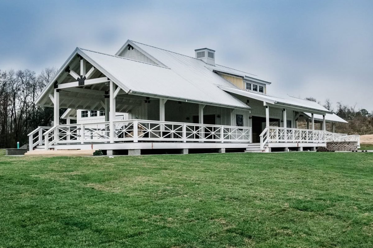 Event venue with wraparound covered porch and standing seam metal roof